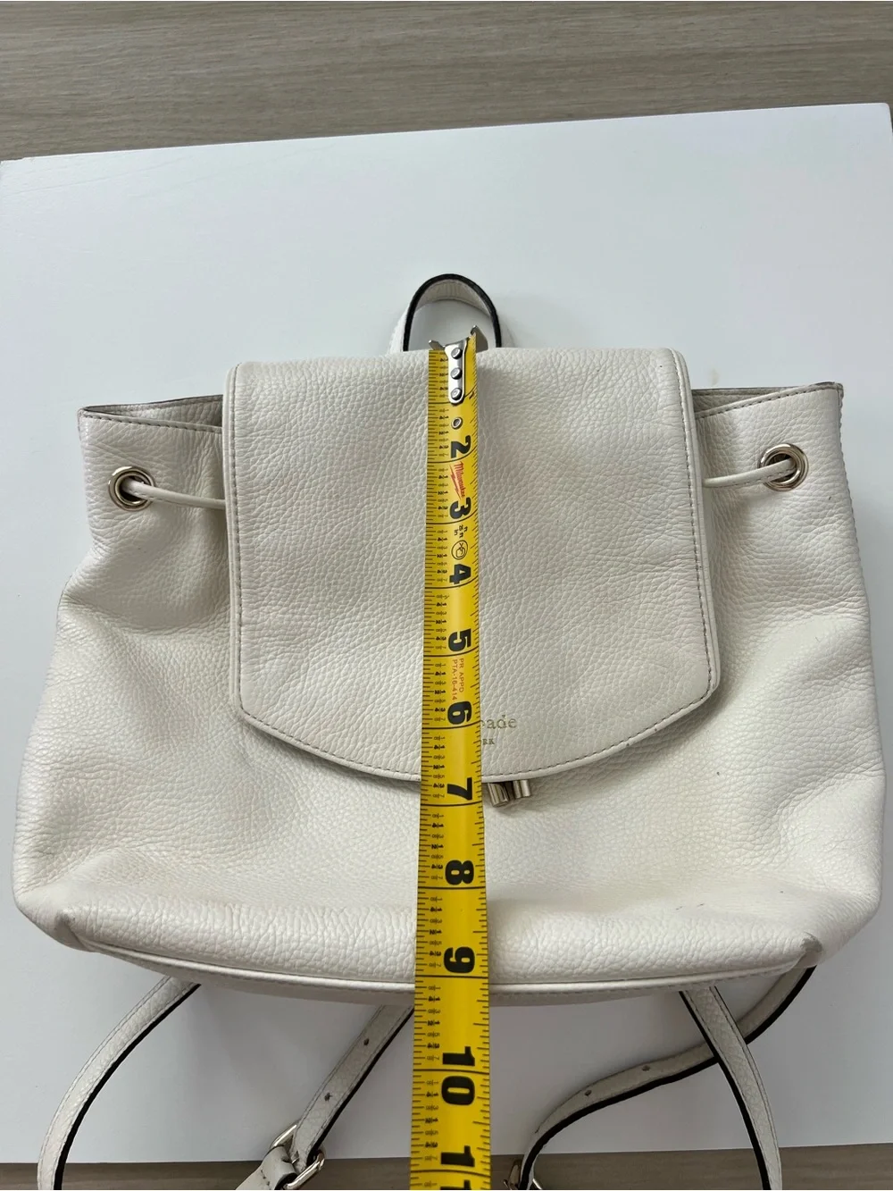 Kate Spade New York creamy white leather drawstring flap backpack